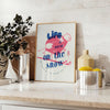 Maximalist poster featuring a snowy landscape with bold blue and white colors - styled on a counter with eucalyptus and a bowl of lemons
