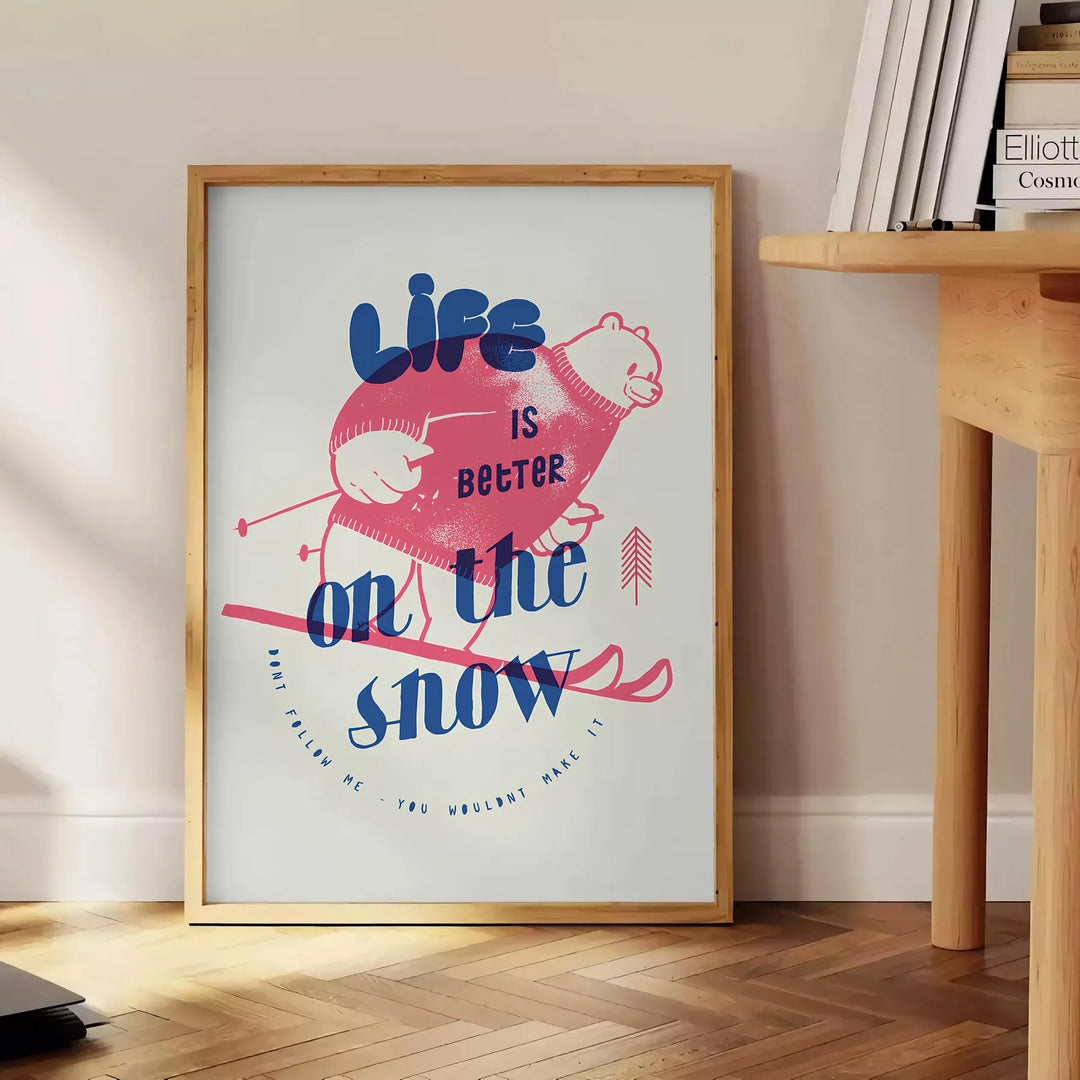 Maximalist poster featuring a snowy landscape with bold blue and white colors - beside a round wooden side table with books