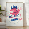 Maximalist poster featuring a snowy landscape with bold blue and white colors - in a bright minimalist room with a plant and an armchair