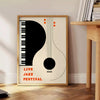 Maximalist print featuring an abstract depiction of a jazz festival with orange and black tones - beside a round wooden side table with books