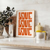 Un poster motivant avec la phrase 'Love Love Love' dans des tons chauds de marron et d'orange - sur un plan de travail avec eucalyptus et coupe de citrons