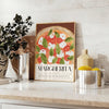 A colorful Margherita pizza illustration with fresh basil on a wooden table - styled on a counter with eucalyptus and a bowl of lemons