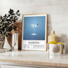 Illustration of a martini cocktail with a sleek black background and green accents - styled on a counter with eucalyptus and a bowl of lemons
