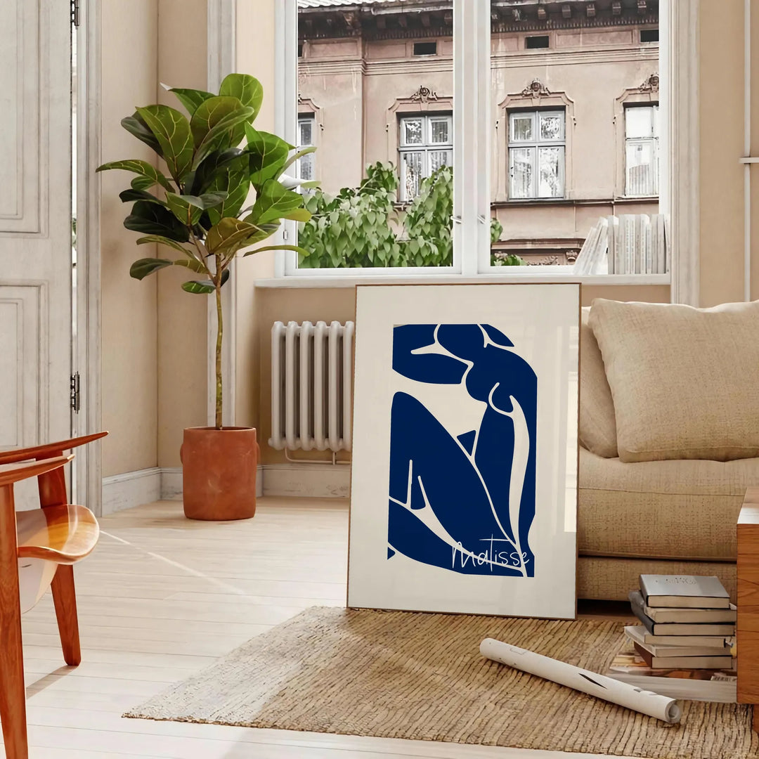 Gray and white cut-out shapes in Matisse's papier découpés style - in a Parisian living room with a sofa and a fig plant