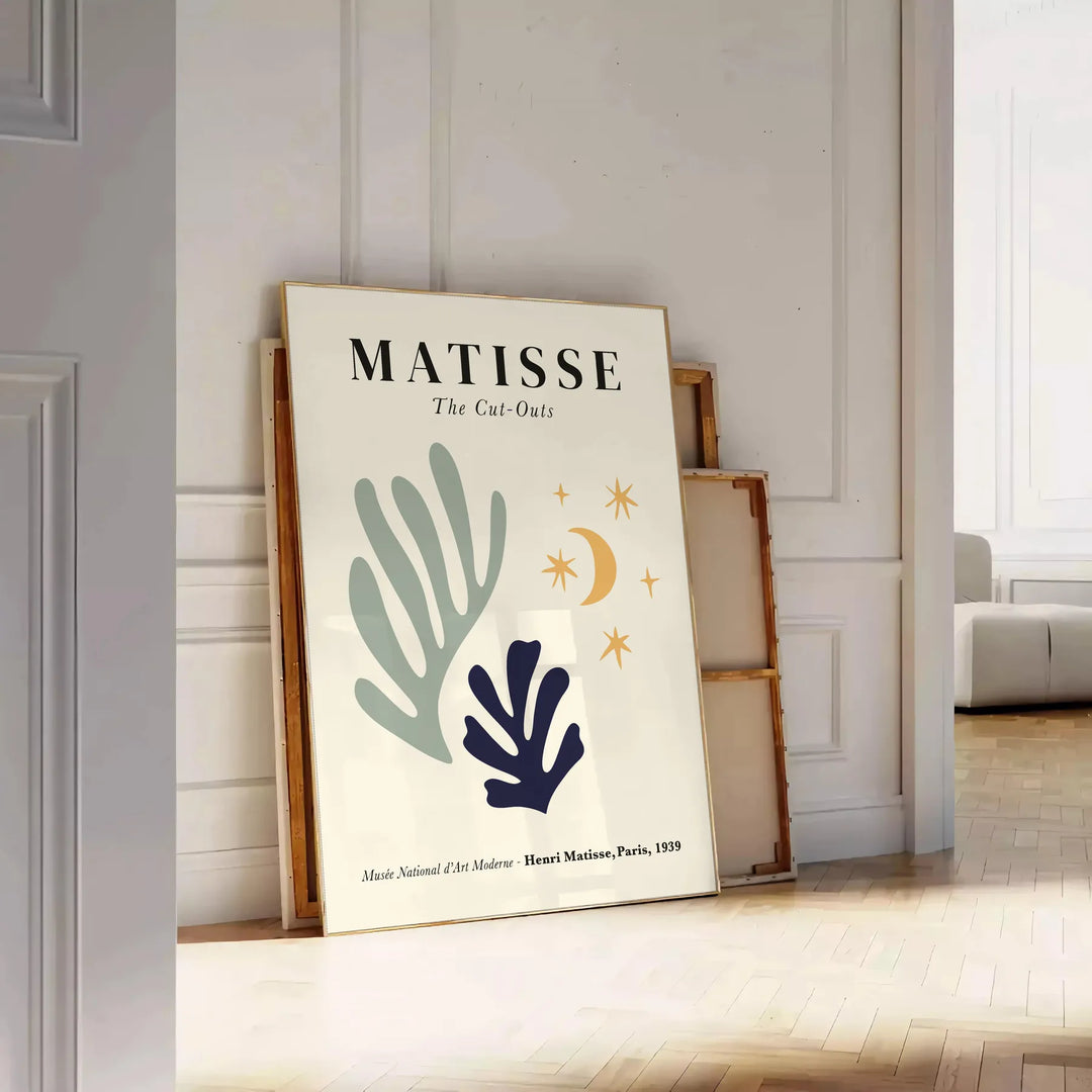 Abstract cut-out shapes in bold colors inspired by Matisse - leaning on a herringbone floor against a white panelled wall