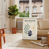 Abstract cut-out shapes in bold colors inspired by Matisse - in a Parisian living room with a sofa and a fig plant