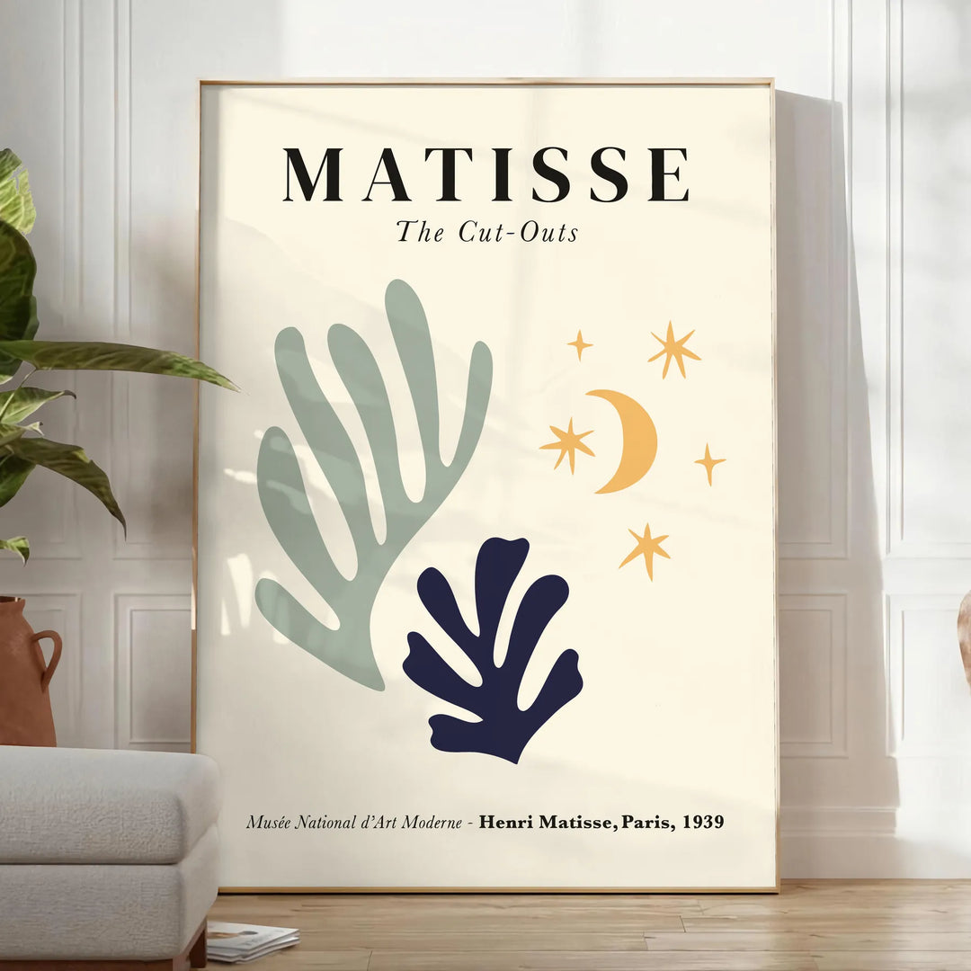 Abstract cut-out shapes in bold colors inspired by Matisse - in a bright minimalist room with a plant and an armchair