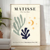 Abstract cut-out shapes in bold colors inspired by Matisse - in a bright minimalist room with a plant and an armchair