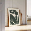 Gray and white poster of Matisse paper cut abstract shapes, minimalist. - leaning on a herringbone floor against a white panelled wall