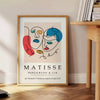 Abstract cut-paper composition in white and yellow by Matisse - beside a round wooden side table with books