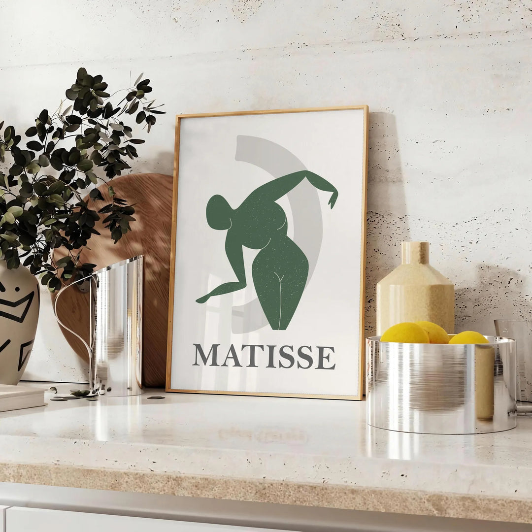 Plakāts bez rāmja ar krāsainu Matisse darbu grieztā papīra tehnikā, abstraktas formas - uz letes ar eikaliptu un citronu bļodu