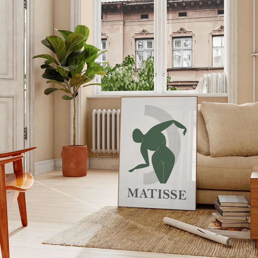 Plakāts bez rāmja ar krāsainu Matisse darbu grieztā papīra tehnikā, abstraktas formas - parīzīgā viesistabā ar dīvānu un fikusu