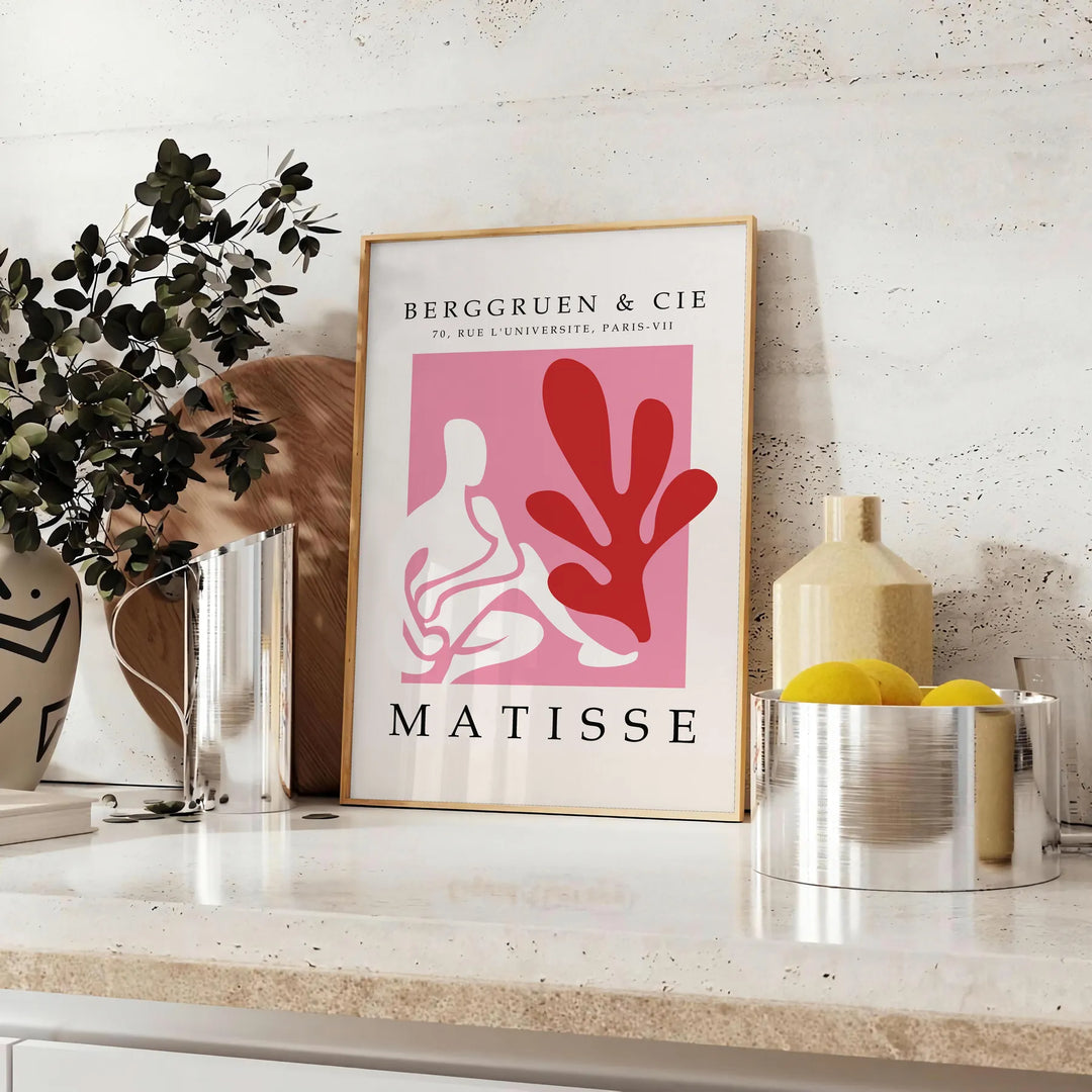 Poster showing Matisse-style papier découpé abstract red and gray shapes - styled on a counter with eucalyptus and a bowl of lemons