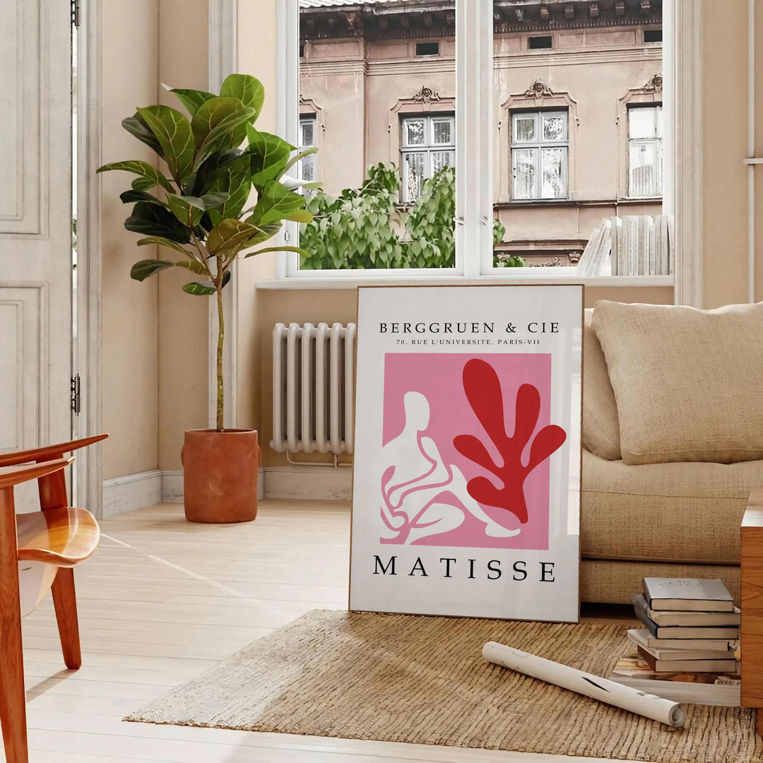 Poster showing Matisse-style papier découpé abstract red and gray shapes - in a Parisian living room with a sofa and a fig plant