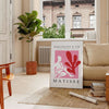 Poster showing Matisse-style papier découpé abstract red and gray shapes - in a Parisian living room with a sofa and a fig plant