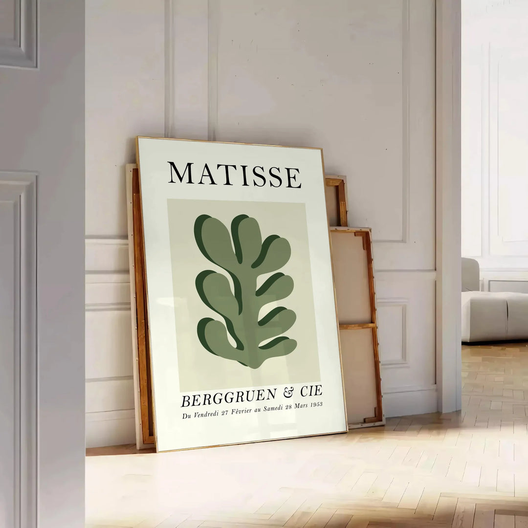 Matisse papier découpés poster with gray and white abstract cutout shapes - leaning on a herringbone floor against a white panelled wall