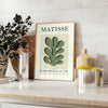 Matisse papier découpés poster with gray and white abstract cutout shapes - styled on a counter with eucalyptus and a bowl of lemons