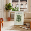Matisse papier découpés poster with gray and white abstract cutout shapes - in a Parisian living room with a sofa and a fig plant