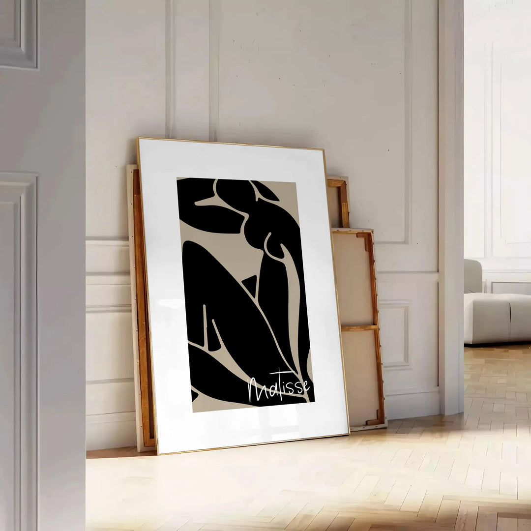 Poster showing Matisse-style abstract cut-out shapes in bold colors - leaning on a herringbone floor against a white panelled wall
