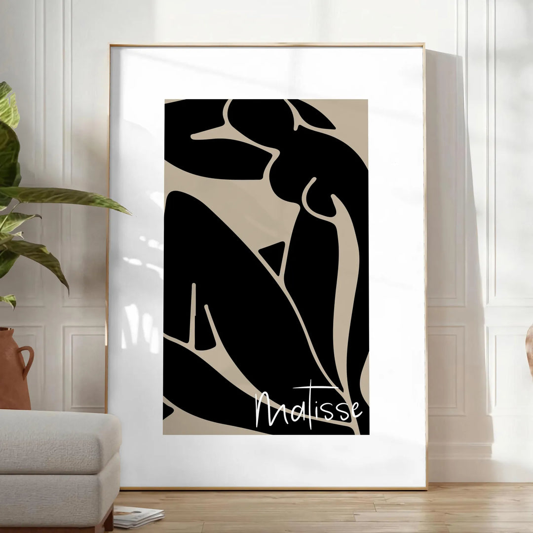 Poster showing Matisse-style abstract cut-out shapes in bold colors - in a bright minimalist room with a plant and an armchair