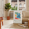 Abstract cut-out design in white and yellow by Matisse - in a Parisian living room with a sofa and a fig plant