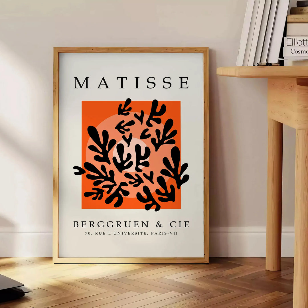 Póster en blanco y negro de composición abstracta recortada de Matisse - junto a una mesa auxiliar redonda de madera con libros