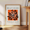 Póster en blanco y negro de composición abstracta recortada de Matisse - junto a una mesa auxiliar redonda de madera con libros