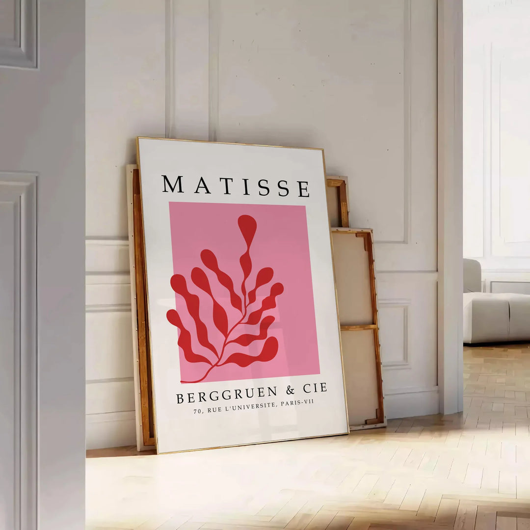 Abstract cut-paper collage by Matisse featuring gray and red shapes - leaning on a herringbone floor against a white panelled wall