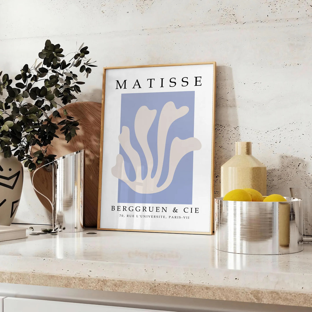Poster showing Matisse paper cut-out artwork in bold abstract shapes - styled on a counter with eucalyptus and a bowl of lemons