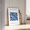 Poster of Matisse-style paper cutout composition in white and green - leaning on a herringbone floor against a white panelled wall