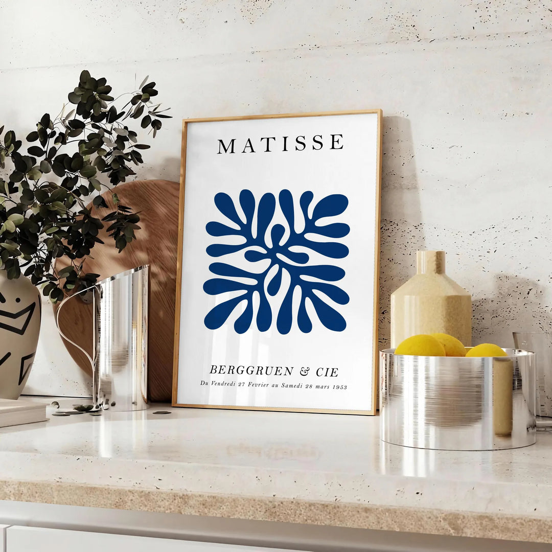 Poster of Matisse-style paper cutout composition in white and green - styled on a counter with eucalyptus and a bowl of lemons