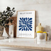 Poster of Matisse-style paper cutout composition in white and green - styled on a counter with eucalyptus and a bowl of lemons