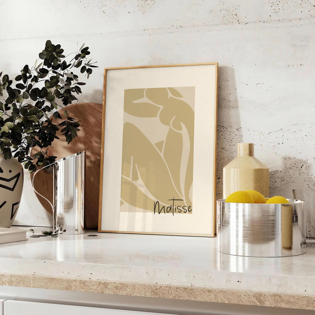 Henri Matisse paper cutouts in abstract shapes with gray and orange tones - styled on a counter with eucalyptus and a bowl of lemons