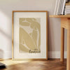 Henri Matisse paper cutouts in abstract shapes with gray and orange tones - beside a round wooden side table with books