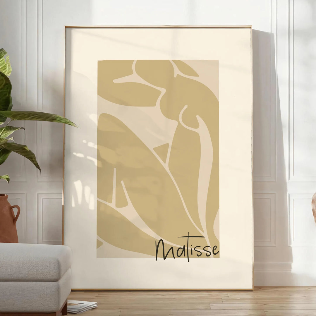 Henri Matisse paper cutouts in abstract shapes with gray and orange tones - in a bright minimalist room with a plant and an armchair