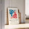 Colorful abstract cut-out shapes in the style of Matisse - leaning on a herringbone floor against a white panelled wall