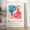 Colorful abstract cut-out shapes in the style of Matisse - in a bright minimalist room with a plant and an armchair
