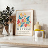 Poster showing colorful abstract paper cutouts in Matisse style artwork - styled on a counter with eucalyptus and a bowl of lemons