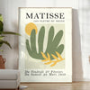 Gray and white poster featuring Matisse-inspired paper cutout abstract composition - in a bright minimalist room with a plant and an armchair