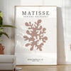 Abstract cut-out shapes in bold colors inspired by Matisse - in a bright minimalist room with a plant and an armchair