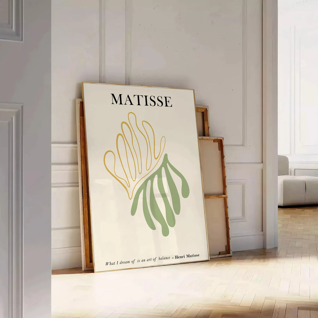 Poster showing Matisse paper cutouts artwork with gray and yellow - leaning on a herringbone floor against a white panelled wall