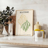 Poster showing Matisse paper cutouts artwork with gray and yellow - styled on a counter with eucalyptus and a bowl of lemons