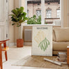 Poster showing Matisse paper cutouts artwork with gray and yellow - in a Parisian living room with a sofa and a fig plant