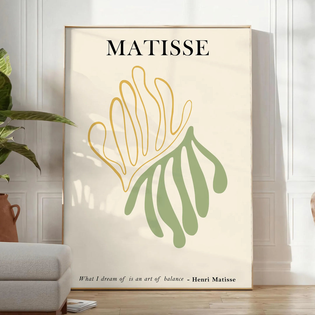 Poster showing Matisse paper cutouts artwork with gray and yellow - in a bright minimalist room with a plant and an armchair