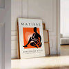 Colorful cut-out shapes in the style of Matisse - leaning on a herringbone floor against a white panelled wall