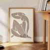 Abstract paper cut design by Matisse in gray and black - beside a round wooden side table with books