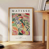Abstract composition with bold colors and shapes inspired by Matisse - beside a round wooden side table with books