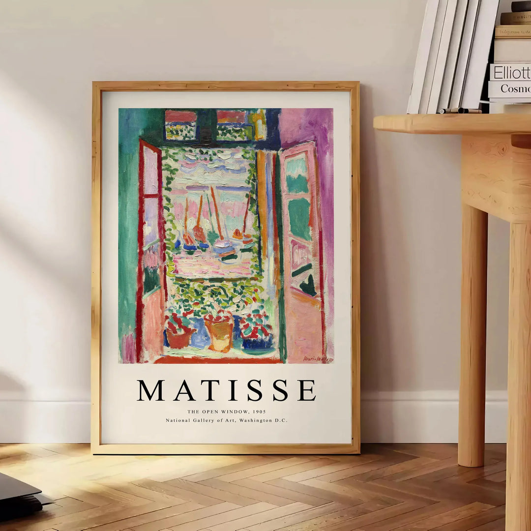 Matisse-inspired cutout design with orange and blue shapes - beside a round wooden side table with books
