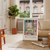 Matisse-inspired cutout design with orange and blue shapes - in a Parisian living room with a sofa and a fig plant