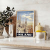 Stylized illustration of Milan's skyline in black and green - styled on a counter with eucalyptus and a bowl of lemons